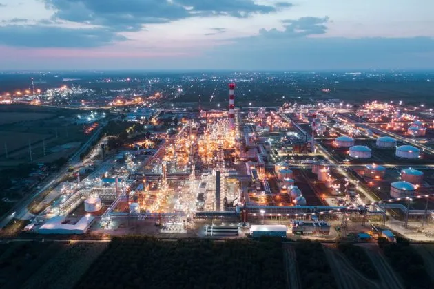 Rafinărie iluminată la apus, simbol al industriei petroliere din Serbia.