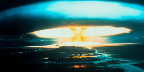 Explozie nucleară cu nori de fum și lumină intensă.