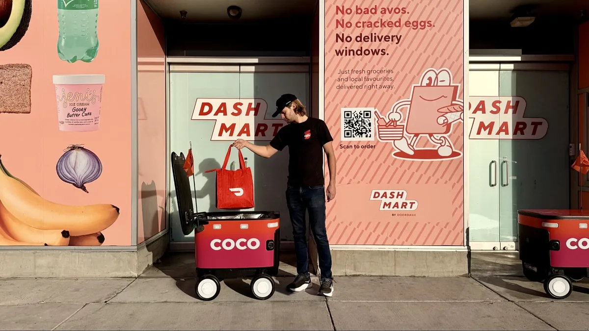 Robot de livrare Coco în fața unui magazin.