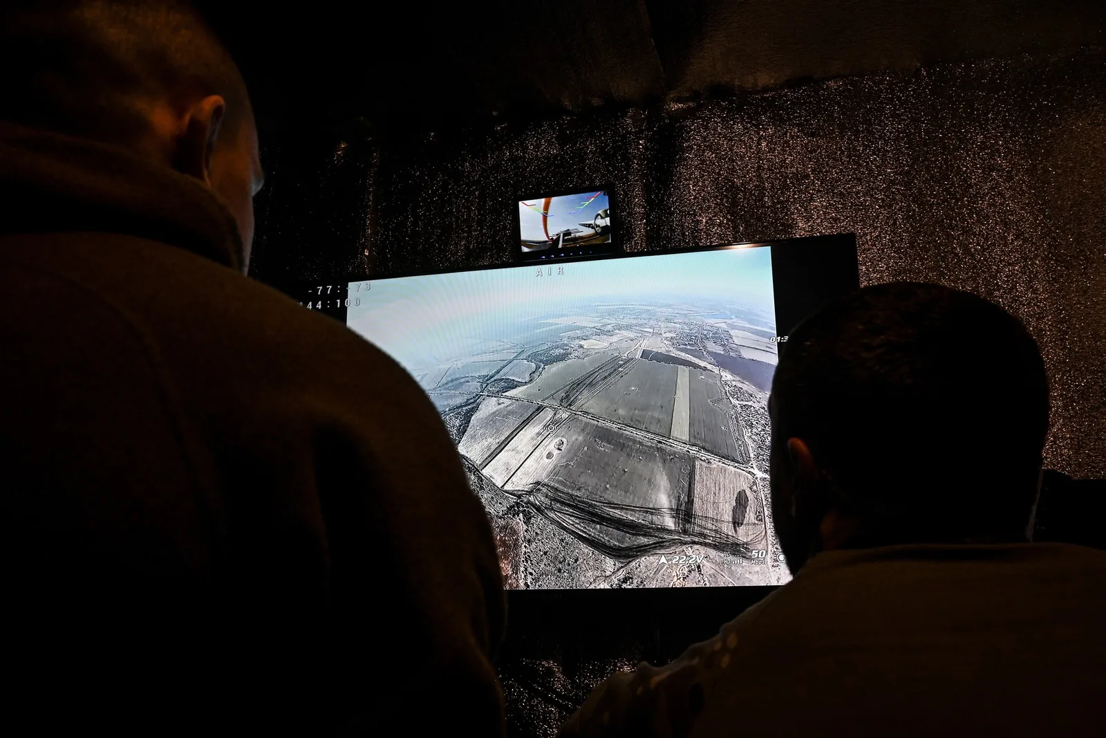 Civili instruiți monitorizează dronele pe un ecran de control avansat.