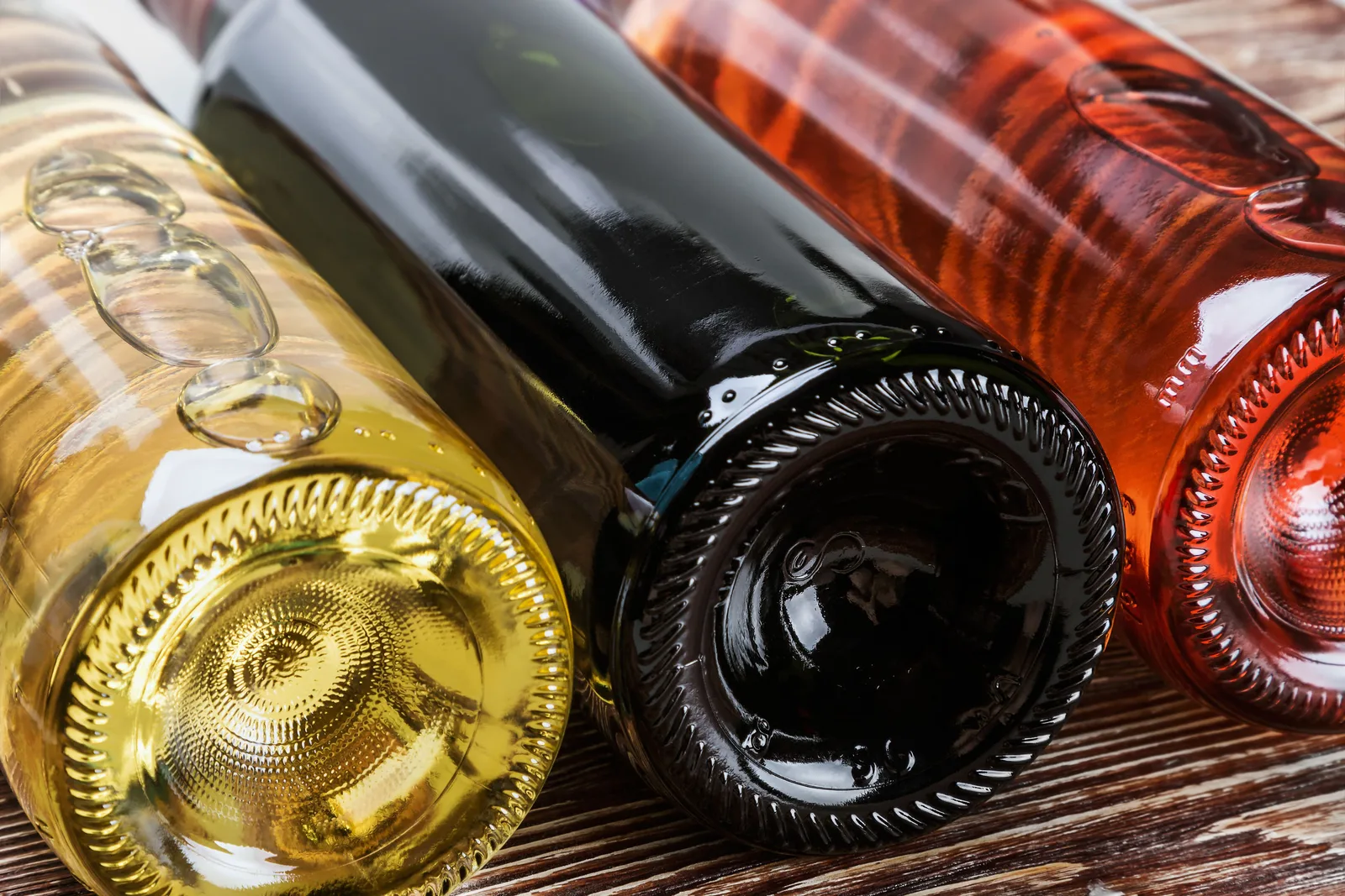 Sticle de vin românesc expuse pe o masă din lemn.
