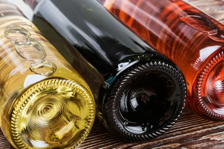 Sticle de vin românesc expuse pe o masă din lemn.