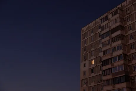 Clădire în Kiev sub cerul întunecat, cu o fereastră iluminată.
