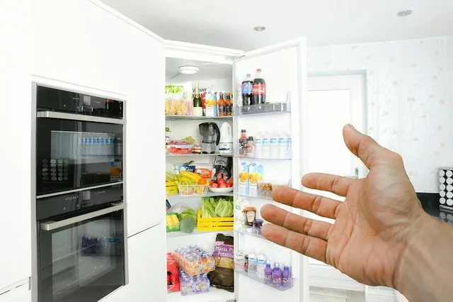 Interiorul unui frigider plin cu alimente și băuturi diverse.
