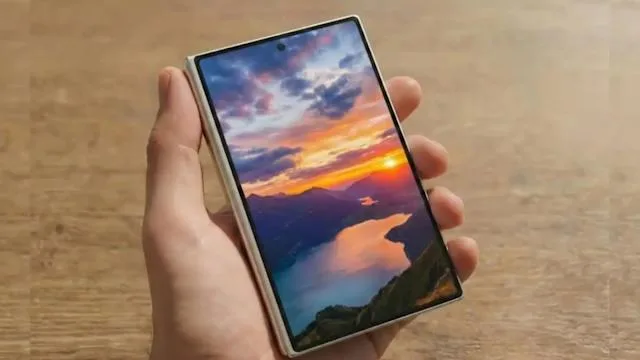 Un telefon pliabil cu ecran OLED M13, pe fundal de apus.