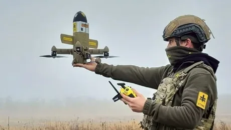 Un soldat ucrainean lansează o dronă pe câmpul de luptă.