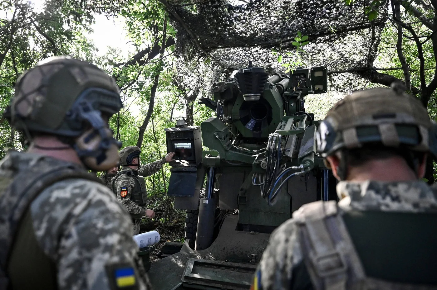 Soldați ucraineni pregătesc echipamente militare în teren.