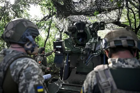 Soldați ucraineni pregătesc echipamente militare în teren.