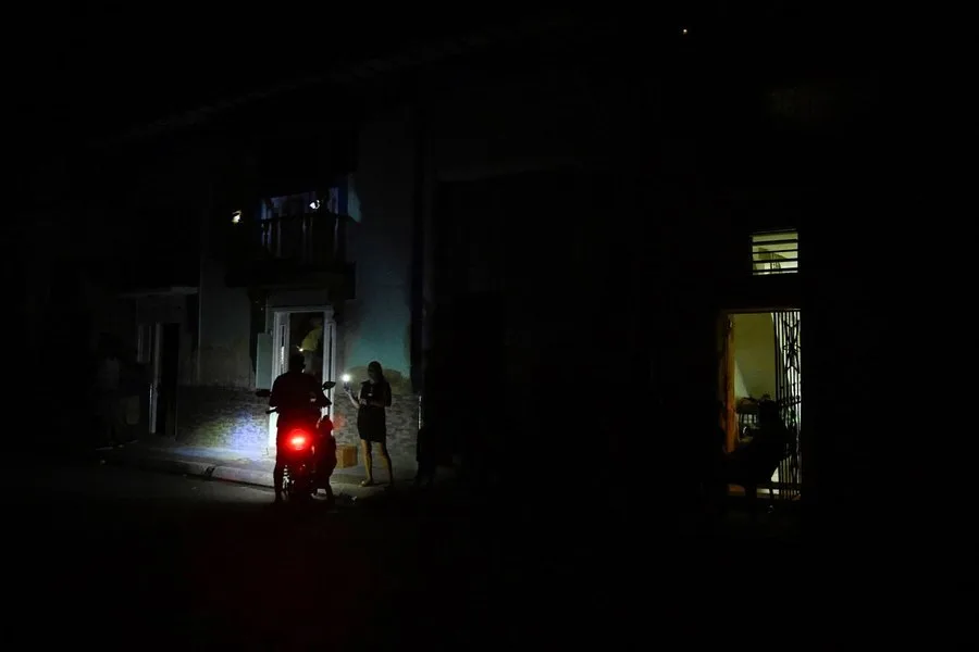 Oameni pe stradă în întuneric, afectati de penele de curent din Cuba.
