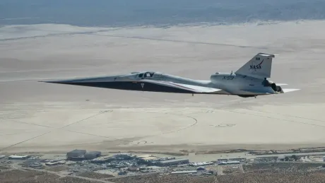 Avionul X-59 în timpul zborului supersonic deasupra peisajului arid.