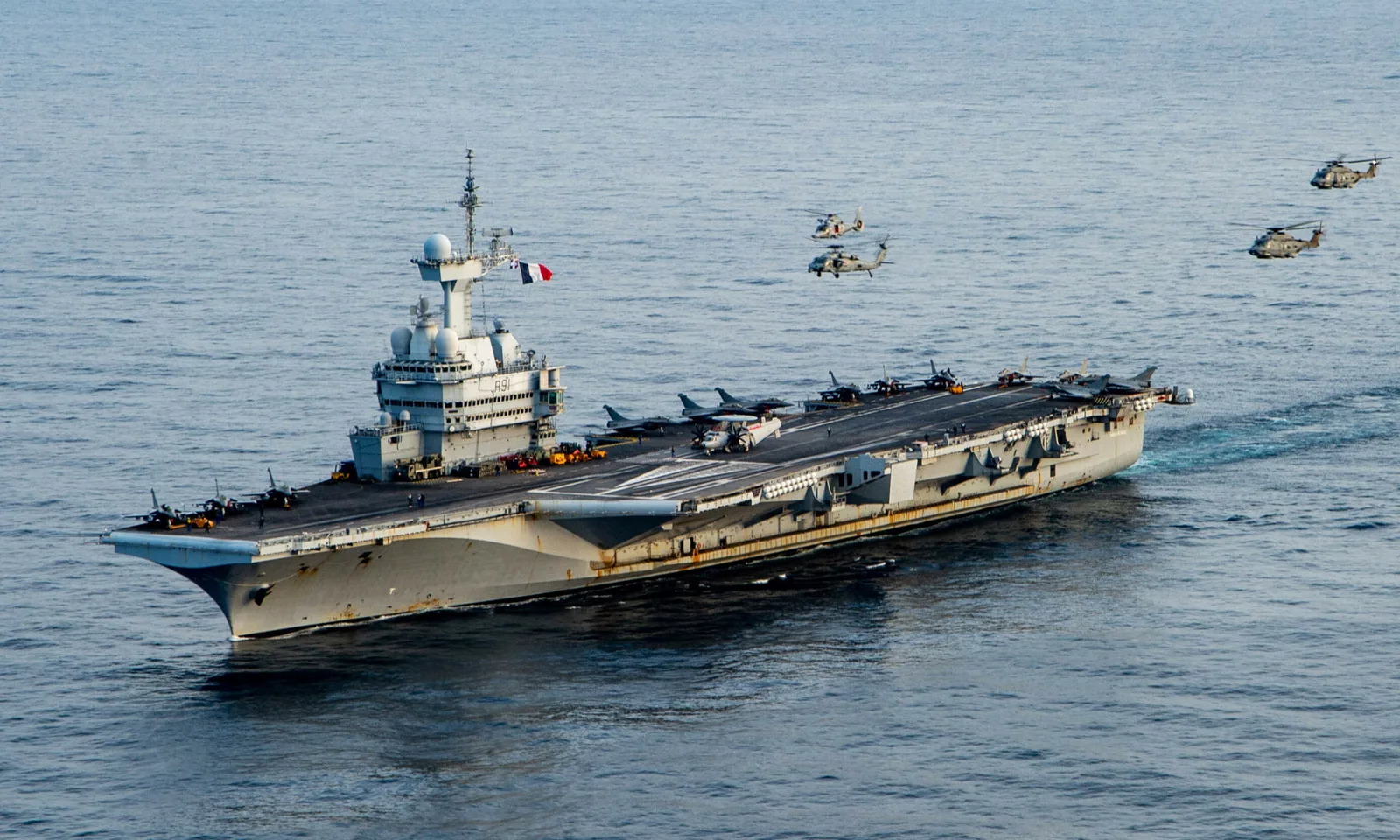 Portavionul Charles-de-Gaulle navigând în Marea Mediterană, cu elicoptere în zbor.