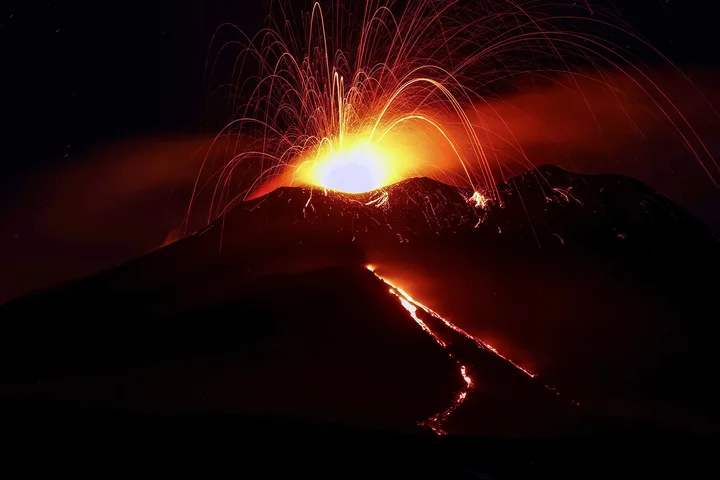 Erupția vulcanului Etna, cu flăcări și cenușă în aer.