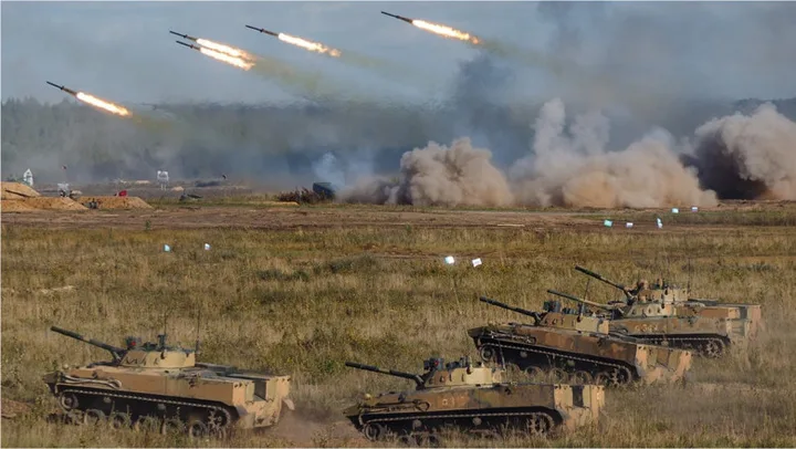 Tancuri și rachete în timpul unui exercițiu militar pe câmpul de luptă.
