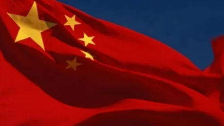 Steagul Chinei fluturând pe un fundal albastru, simbol al puterii economice.