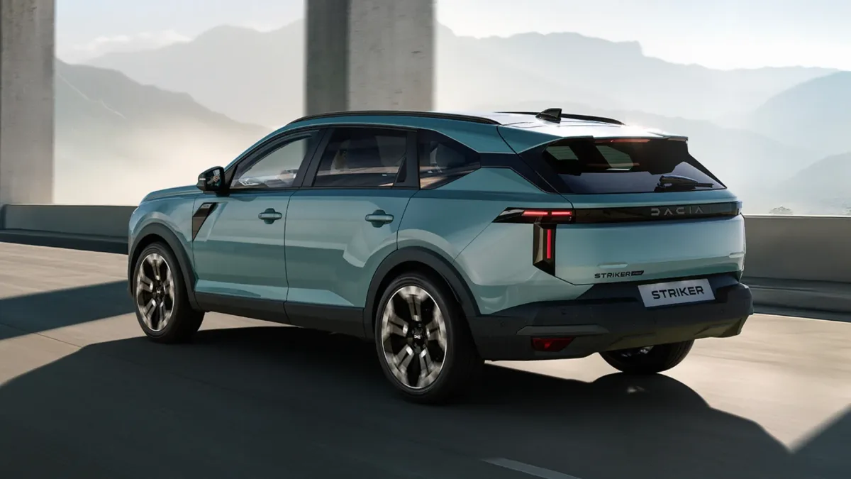 Dacia Striker în mișcare pe un drum montan, cu peisaj de fundal.