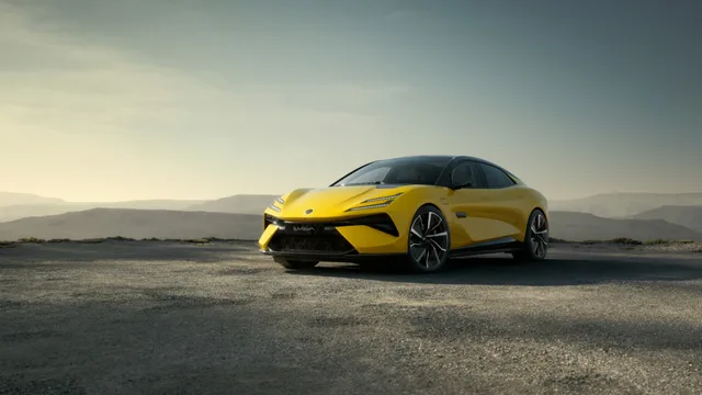 Un automobil Lotus galben pe un drum de munte, în lumina dimineții.