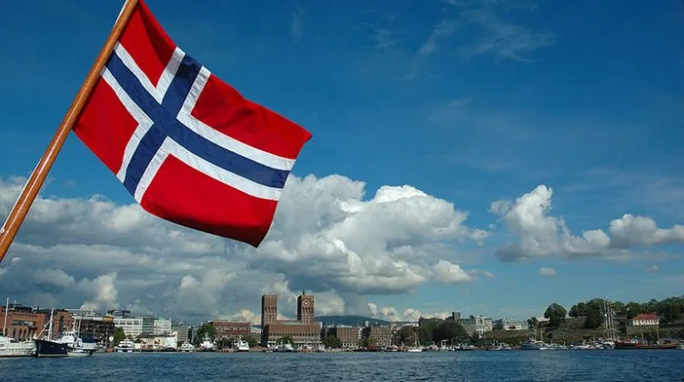 Steagul Norvegiei fluturând pe fundalul unui peisaj urban frumos.