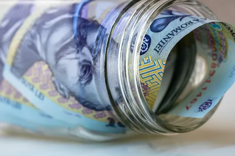 Bancnote românești așezate într-un borcan de sticlă.