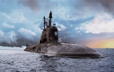 Submarin nuclear în apă, cu cer noros și apus.