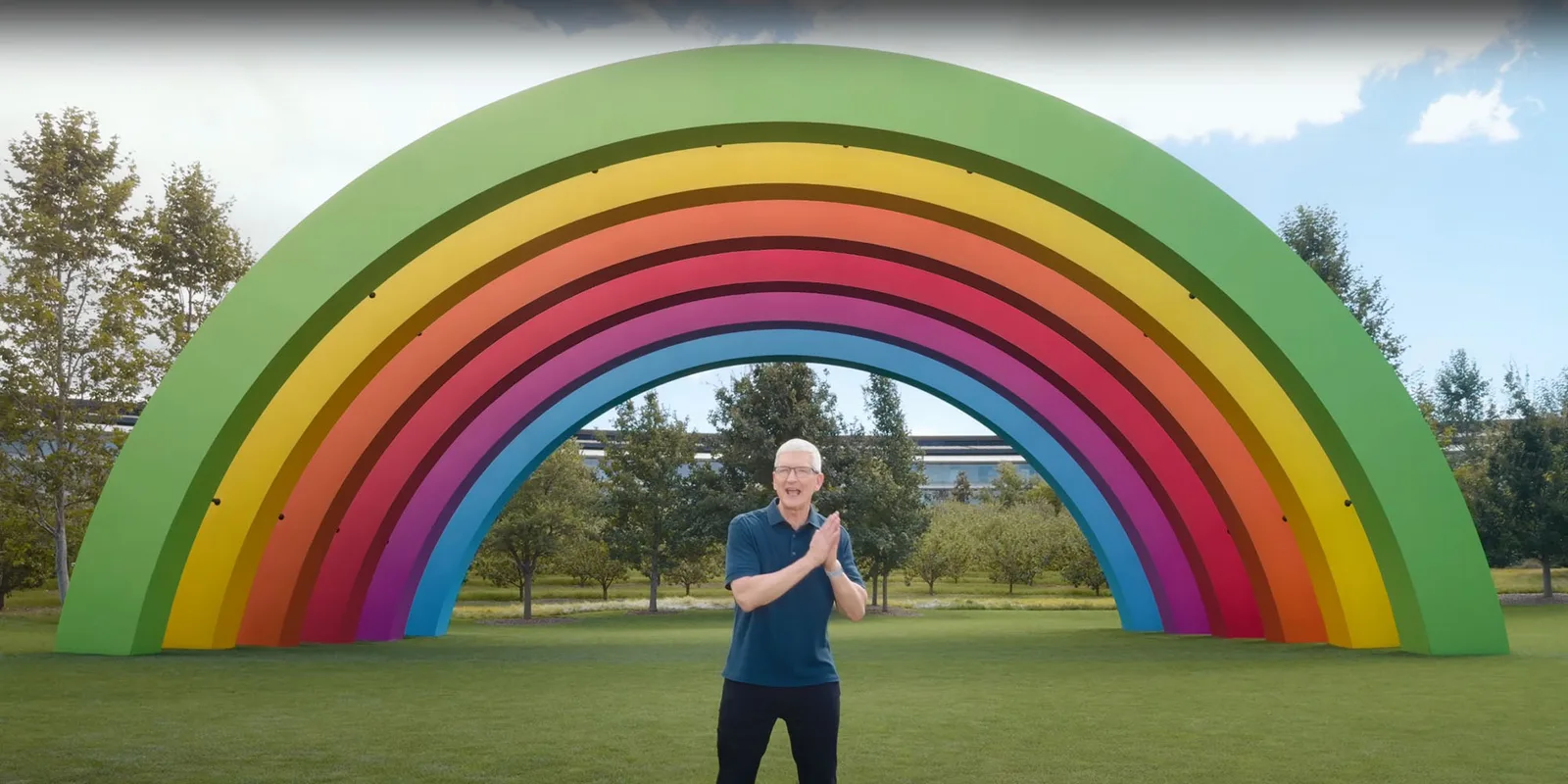 Tim Cook salută cu entuziasm sub un curcubeu colorat.