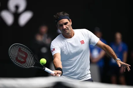 Roger Federer pregătindu-se pentru un meci demonstrativ pe terenul de tenis.
