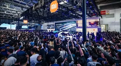O mulțime de oameni admirând inovațiile auto la un salon internațional.