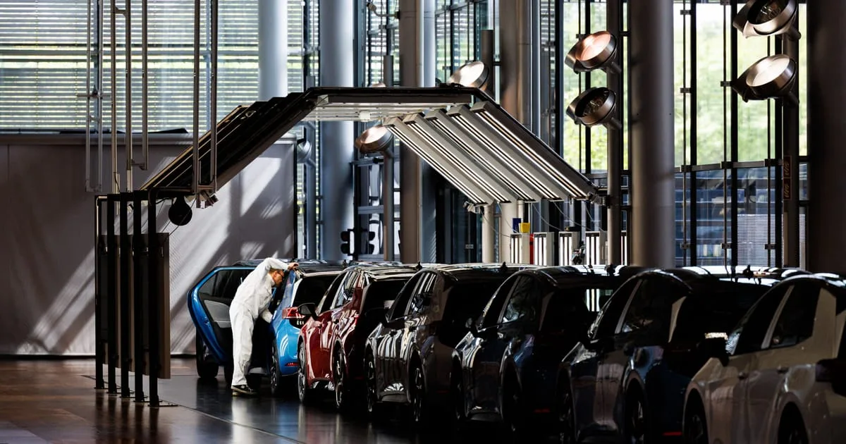 O fabrică auto modernă cu angajați care lucrează la mașini.