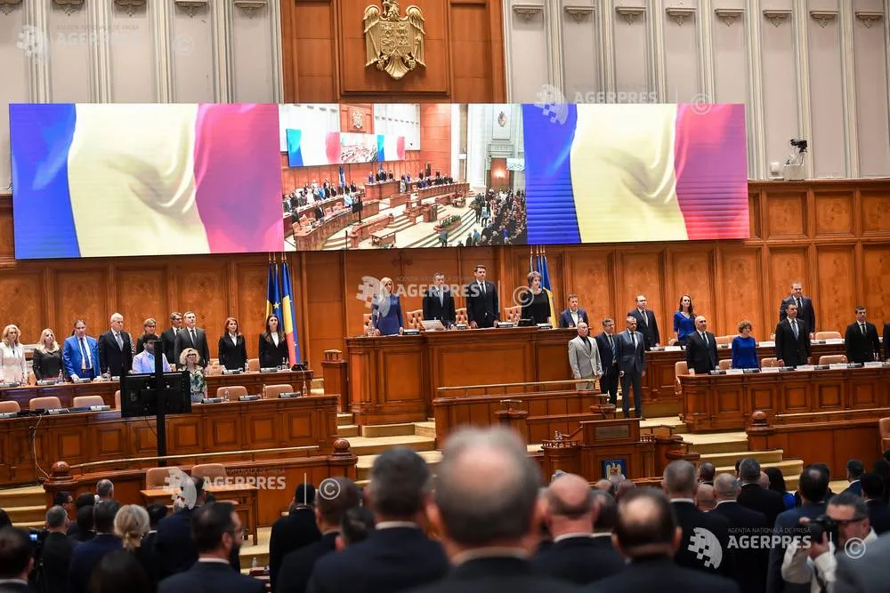 Parlamentarii stau în sala de ședințe, cu drapelul României în fundal.
