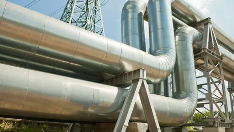 Conductă metalică pentru transport de combustibil militar în peisaj industrial.