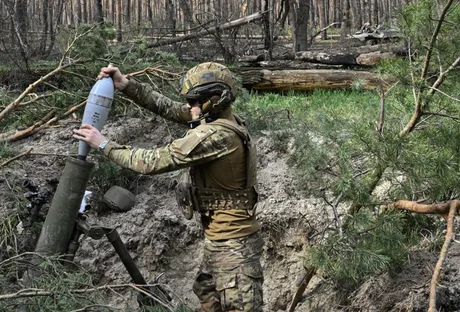 Soldat ucrainean pregătind un obuz într-o zonă de conflict.