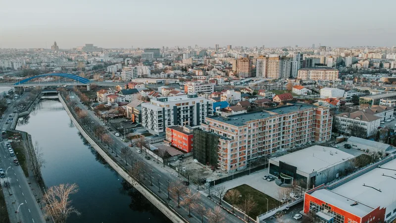Vedere panoramică a unui oraș cu clădiri moderne și un râu.