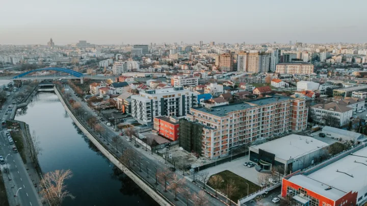 Vedere panoramică a unui oraș cu clădiri moderne și un râu.