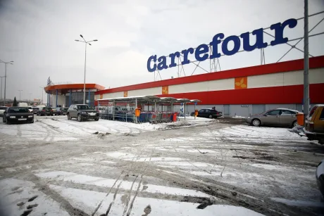 Magazin Carrefour cu parcări și zăpadă în jur.