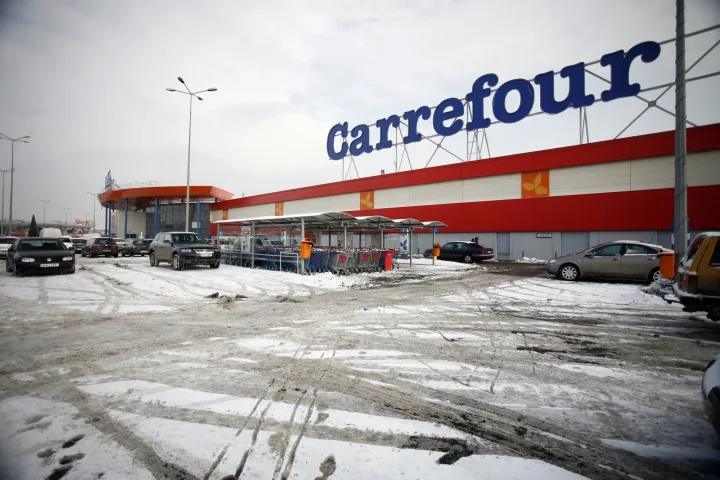Magazin Carrefour cu parcări și zăpadă în jur.