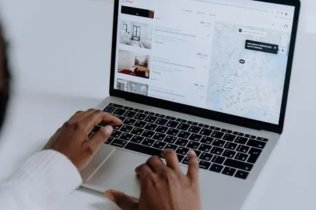 Utilizator navigând pe aplicația Airbnb pentru rezervări și servicii de călătorie.