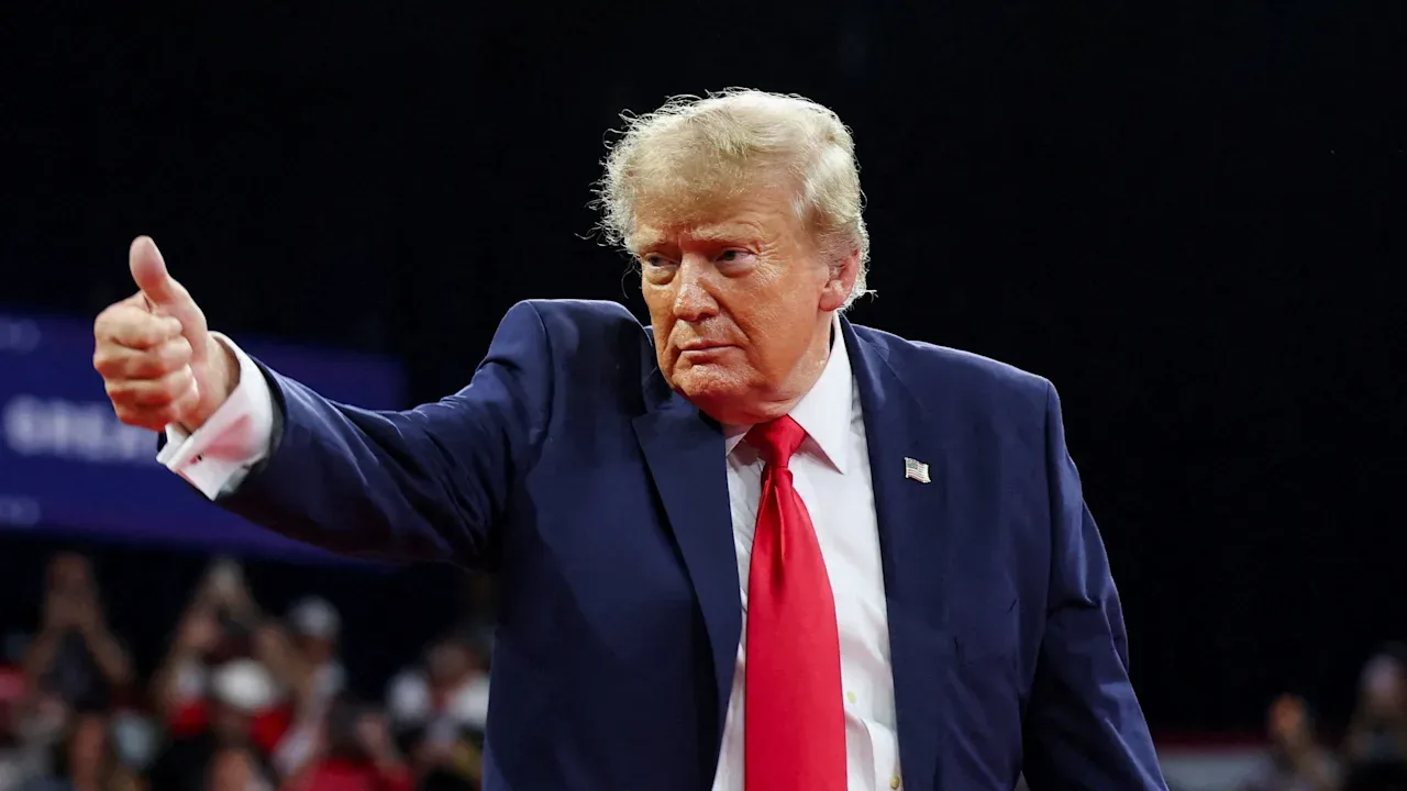 Donald Trump gesticulând pe scenă, exprimându-și opiniile politice.