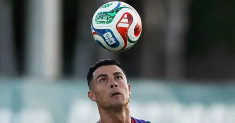 Cristiano Ronaldo urmărește mingea în timpul unui meci de fotbal.