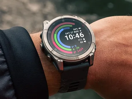 Ceas Garmin pe un braț, cu display colorat și informații de fitness.