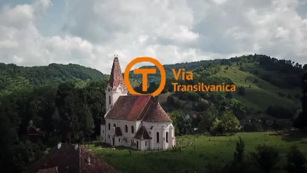 Peisaj rural din România, cu o biserică și dealuri verzi.
