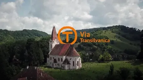 Peisaj rural din România, cu o biserică și dealuri verzi.