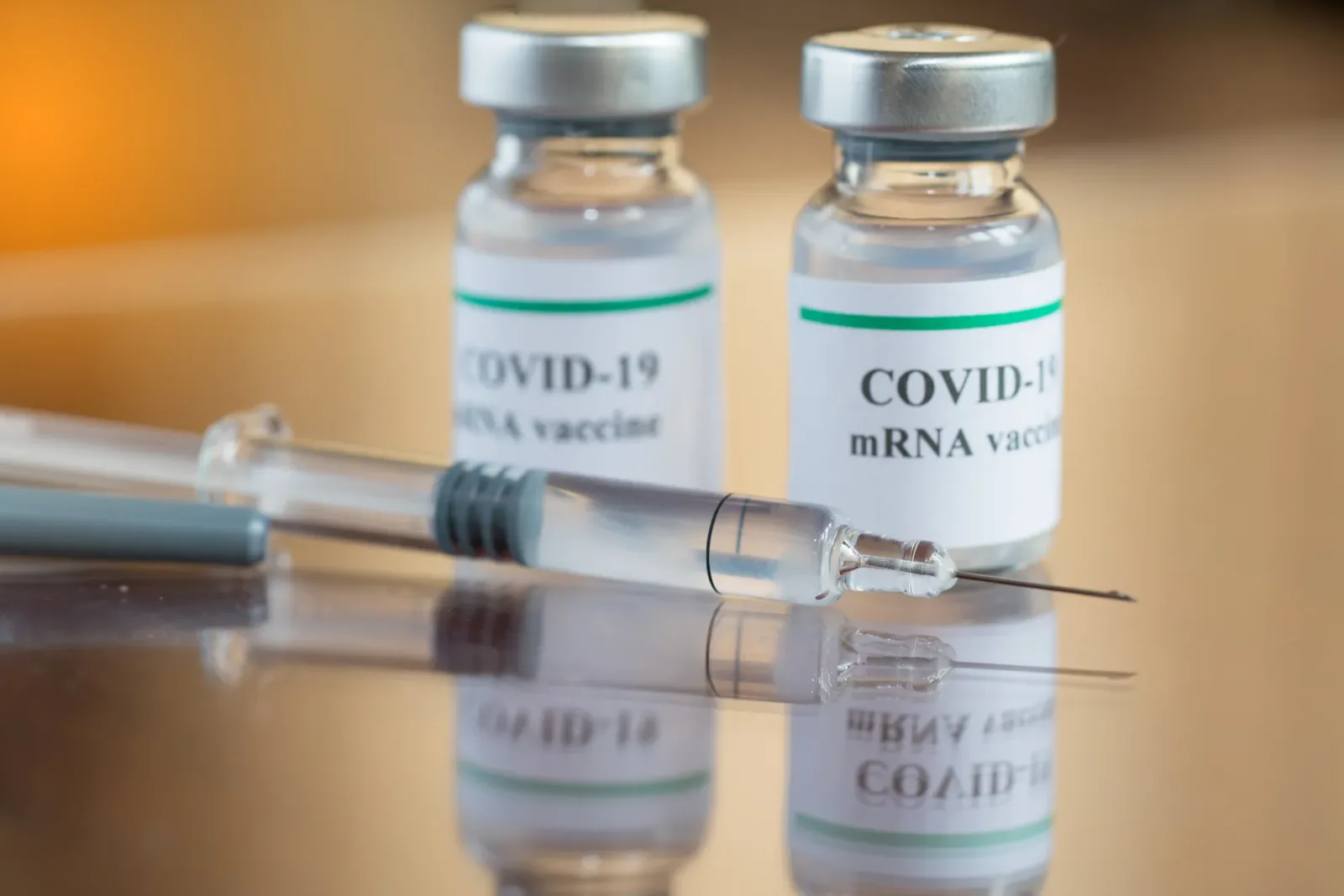 Flacoane de vaccin COVID-19 și seringa pregătită pentru administrare.