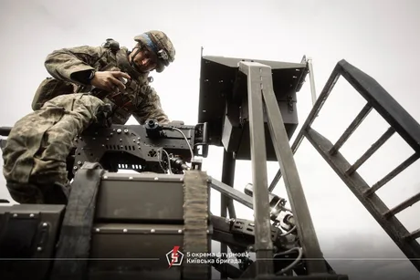 Soldat ucrainean lucrând la un sistem anti-dronă pe câmpul de luptă.