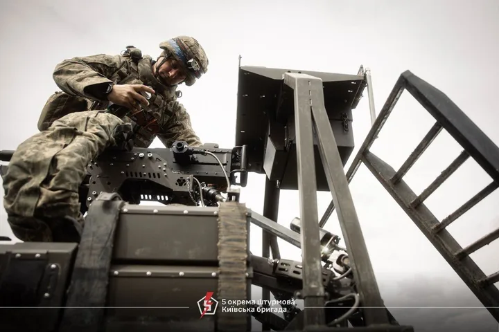 Soldat ucrainean lucrând la un sistem anti-dronă pe câmpul de luptă.