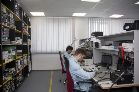 Angajați lucrând în laboratorul de reparații al companiei Depanero.