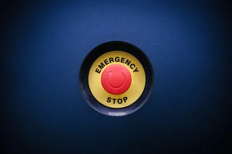 Buton de oprire de urgență, simbolizând riscurile digitale.