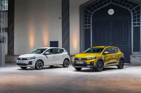 Două modele Dacia expuse într-un spațiu elegant, evidențiind designul modern.