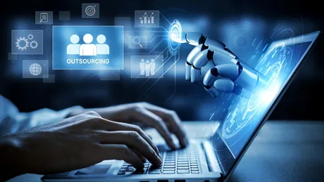 Un robot interacționează cu un laptop, simbolizând inteligența artificială.