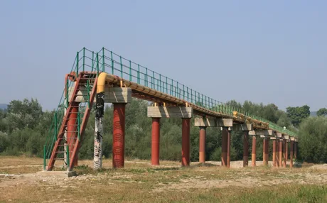 Conductă de petrol pe un peisaj natural, simbolizând relațiile energetice.