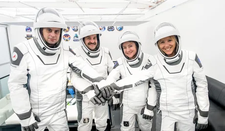 Echipajul Crew-12 pregătit pentru lansare, îmbrăcat în costume spațiale.