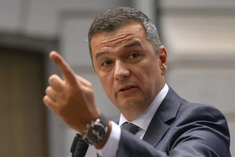 Sorin Grindeanu vorbește cu gesturi expresive la o conferință.